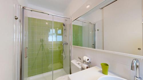 ein Badezimmer mit Waschbecken und Dusche mit Spiegel in der Unterkunft Apartamento Studio Sao Rafael, 450m Praia in Sesmarias