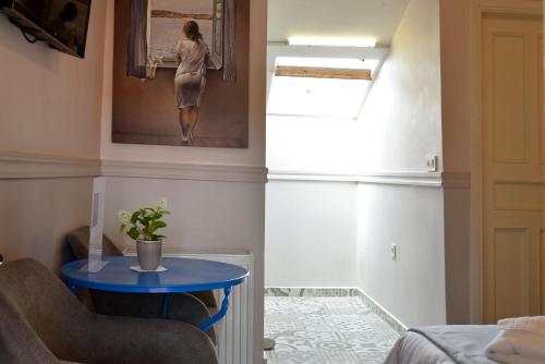 a room with a blue table and a painting on the wall at Pension 2Be in Nafplio