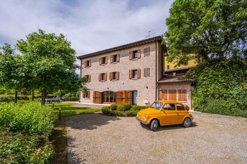 a yellow car parked in front of a building at Residenza Storica sulle Colline di Maranello in Fogliano
