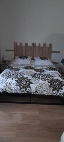 une chambre avec un lit avec une couette noire et blanche dans l'établissement Studio 2 à 4 personnes avec balcon et parking, à La Bourboule