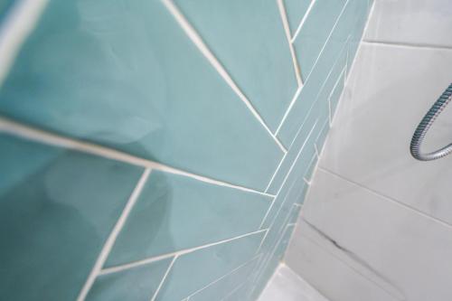 a bathroom with a blue tiled wall and a shower at The Olive Garden-Almyrida in Almirida