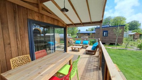 a wooden deck with a wooden table and chairs at Domaine Le Jardin de Séraphine in Malleville-les-Grès