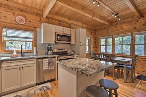 Una cocina con una gran isla en una cabaña de madera. en Private Mountain Creekside Cabin, with Hot Tub, en Purlear