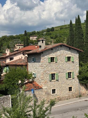 a large stone building with green shutters on it at Dimora del Melograno in Grezzana