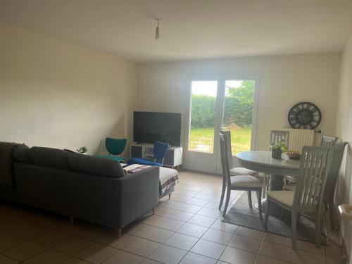 un salon avec un canapé et une table avec des chaises dans l'établissement Chambre chez l habitant, à Saint-Laurent-sur-Sèvre