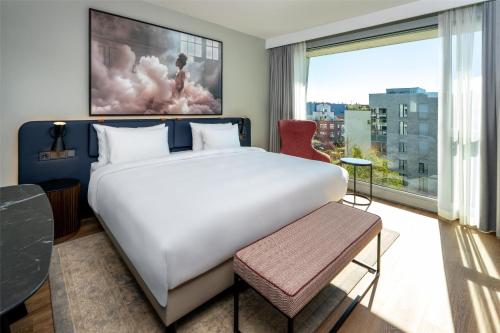 a bedroom with a large bed and a large window at Radisson Blu Media Harbour Hotel, Düsseldorf in Düsseldorf