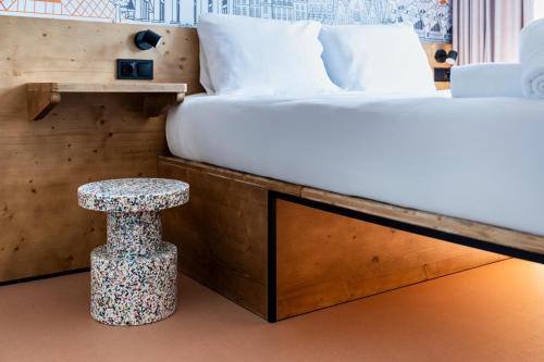 a bedroom with a bed with a stool next to it at easyHotel Barcelona La Sagrera in Barcelona