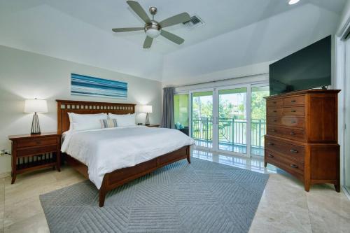 a bedroom with a bed and a dresser and a television at Laguna | Relaxing Family Oasis in Seven Mile Beach