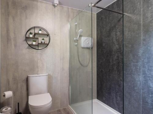 a bathroom with a toilet and a glass shower at Stone Water Cottage in Contin