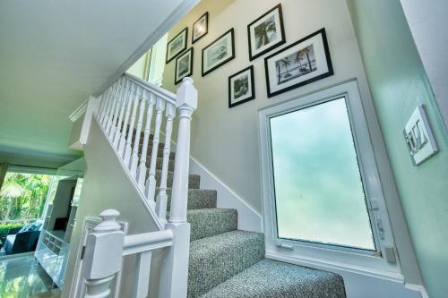 a white staircase with pictures on the wall at Laguna | Relaxing Family Oasis in Seven Mile Beach