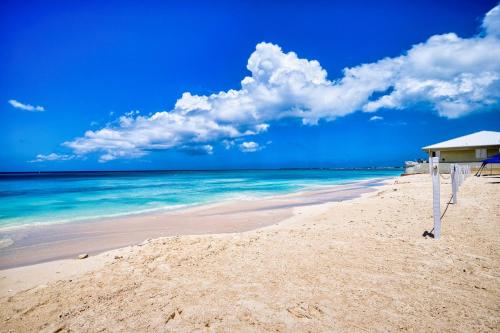 a beach with a building and the ocean at Laguna | Relaxing Family Oasis in Seven Mile Beach