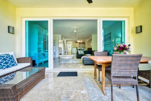 a living room with a wooden table and chairs at Laguna | Relaxing Family Oasis in Seven Mile Beach