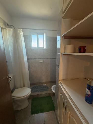a small bathroom with a toilet and a window at Belgrano Calidez Junin in Junín