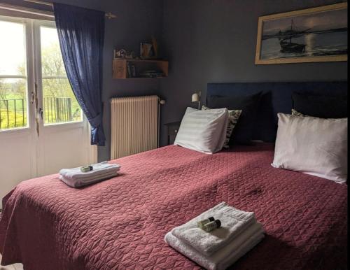 a bedroom with two towels on a bed with a window at Brunsbo G:a Biskopsgård Hotell & Konferens in Skara