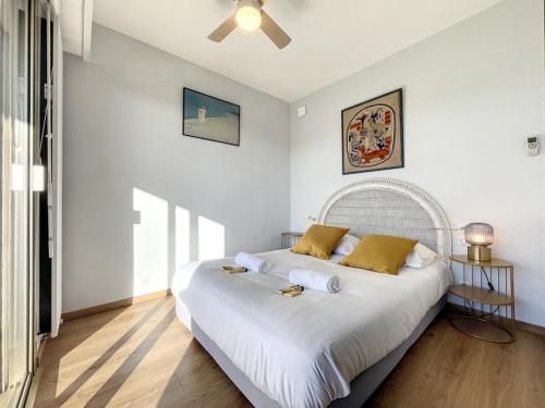 - une chambre blanche avec un grand lit blanc et des oreillers jaunes dans l'établissement Cap d'Antibes 2P garage proche mer Hermitage, à Antibes