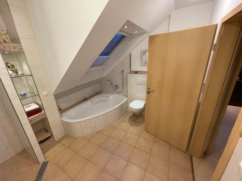 a bathroom with a toilet and a bath tub at Ferienwohnung BK8 Nähe Alfsee, ruhig, top ausgestattet in Bramsche