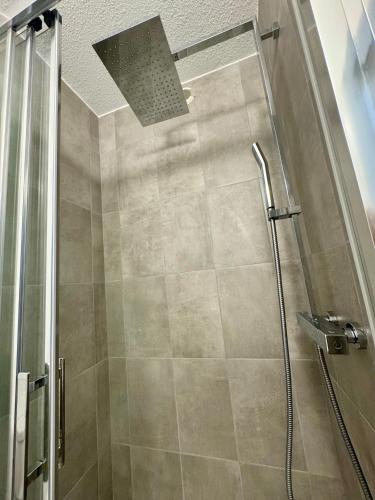 d'une douche avec une porte en verre et un pommeau de douche. dans l'établissement Le petit port - 2pers - Histoire de clés, au Cap d'Agde