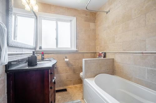a bathroom with a tub and a toilet and a sink at 3 Bedroom Luxury House in Toronto in Toronto