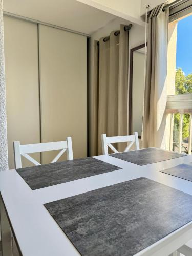 une salle à manger avec une table et deux chaises dans l'établissement Le petit port - 2pers - Histoire de clés, au Cap d'Agde