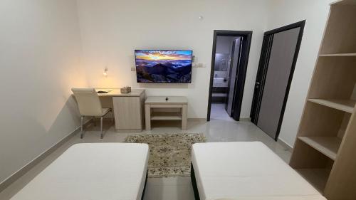 a room with a desk and a table with chairs at Oriental Nights Rest House in Al Wāşil