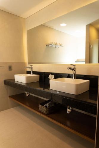 a bathroom with two sinks and a large mirror at Hotel Zuma Colony in Querétaro