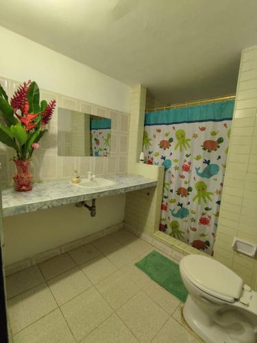 a bathroom with a toilet and a sink and a mirror at Donde Orlando - Guatiguara in Santa Marta