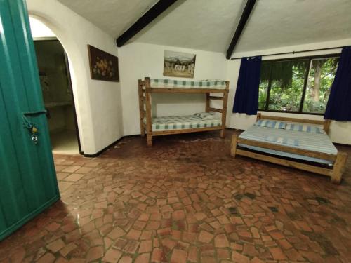 Donde Orlando - Guatiguara في سانتا مارتا: غرفة معيشة بسريرين وباب