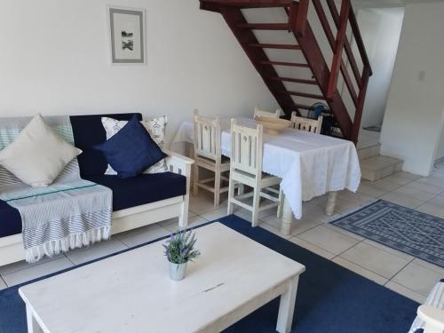 a living room with a couch and a table at Aletheia Abode in Port Alfred