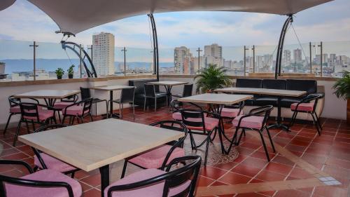 a patio with tables and chairs on a roof at Hotel Alessio in Bucaramanga