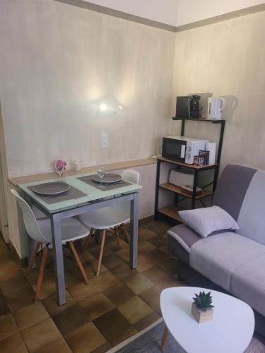 un salon avec une table et un canapé dans l'établissement Studio proche de la mer, à Calvi