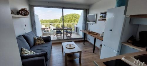un salon avec un canapé et une table dans l'établissement Magnifique studio vue mer à Port Camargue-4 couchages, au Grau-du-Roi
