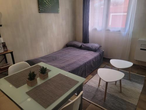 une petite pièce avec un lit, une table et des chaises dans l'établissement Studio proche de la mer, à Calvi