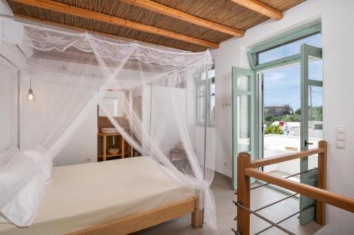 a bedroom with a bed with mosquito nets at Lapis Domus Milos in Plaka Milou