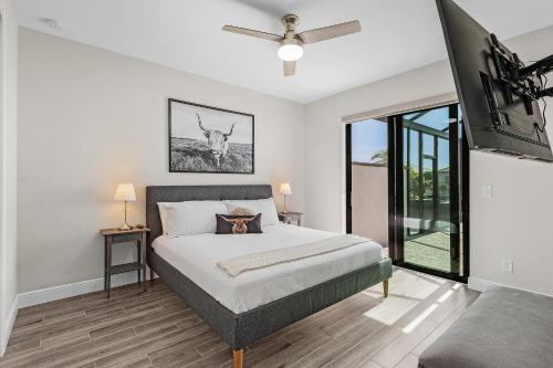 ein Schlafzimmer mit einem Bett und einem Fernseher in der Unterkunft Villa Felicitas Luxe Pool, Jacuzzi Canal Access in Matlacha