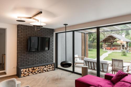 a living room with a tv on a brick wall at CuibuS Lodge in Bran