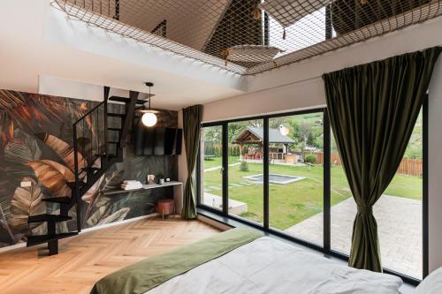 a bedroom with a large window and a bed at CuibuS Lodge in Bran