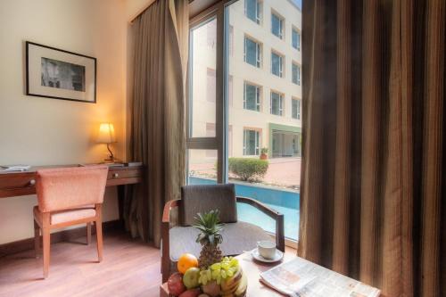 a hotel room with a desk and a table with fruit at The Sky Imperial, Jaipur in Jaipur
