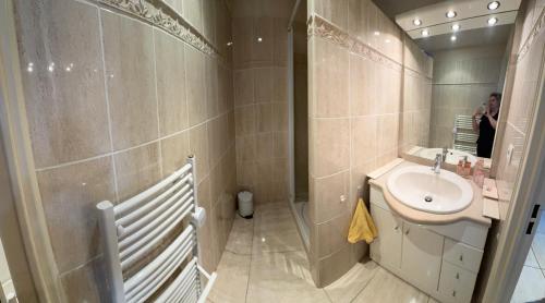 une personne prenant une photo d'une salle de bains avec lavabo dans l'établissement T2 climatisé au cœur de Cavalaire, avec terrasse, garage, proche des plages et commerces- Onda di mar, à Cavalaire-sur-Mer