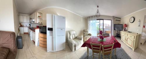 Il dispose d'une cuisine et d'un salon avec une table et un réfrigérateur. dans l'établissement T2 climatisé au cœur de Cavalaire, avec terrasse, garage, proche des plages et commerces- Onda di mar, à Cavalaire-sur-Mer