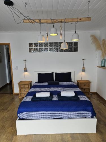 a bedroom with a large blue and white bed with lights at Esplanada do Ilhéu in Vila Franca do Campo