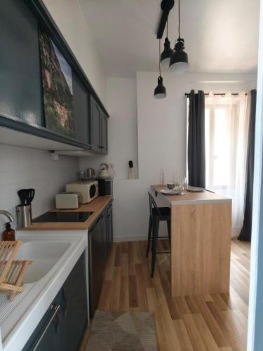 une cuisine avec une table et un comptoir dans l'établissement Studio vue sur le rocher, à Moustiers-Sainte-Marie
