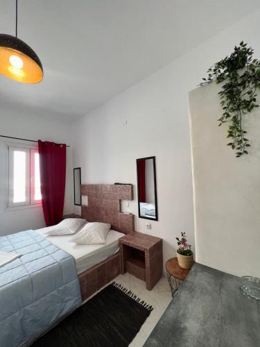 a bedroom with a bed and a red curtain at Santo Margarita in Oia