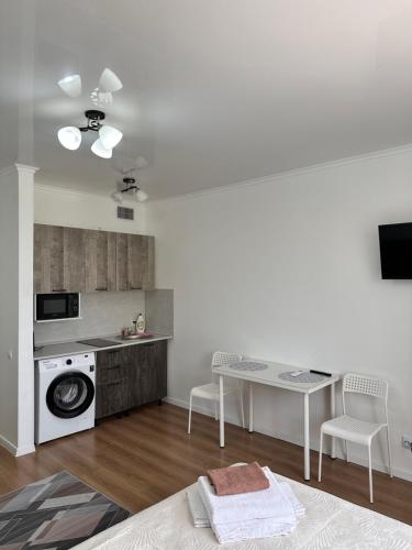 a kitchen with a table and a washing machine at Prominad Burabai 45P in Borovoye