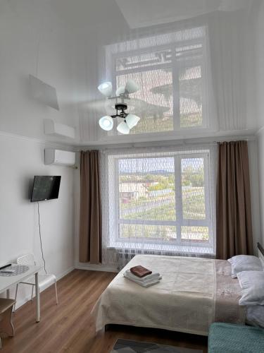 a bedroom with a bed and a large window at Prominad Burabai 45P in Borovoye