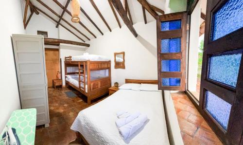 a bedroom with a bed in a room with windows at Cocoa House, Barichara in Barichara