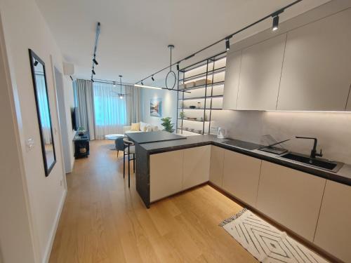 a kitchen with white cabinets and a dining room at New Luxury Suite with Garrage in Belgrade