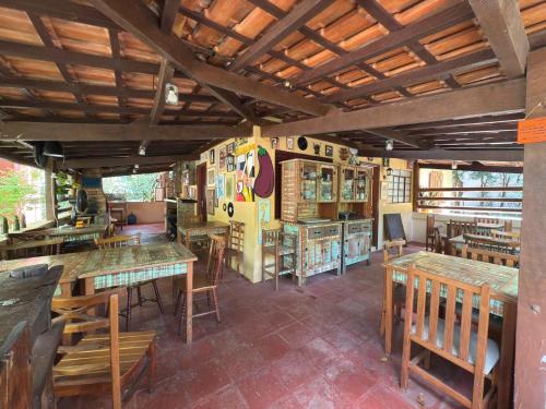 ein Restaurant mit Holztischen und Holzstühlen in der Unterkunft Ecocentro Brasil - Bangalô 1 in São Pedro
