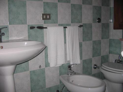 a bathroom with a sink and a toilet and towels at Sa Crannaccia in Càbras