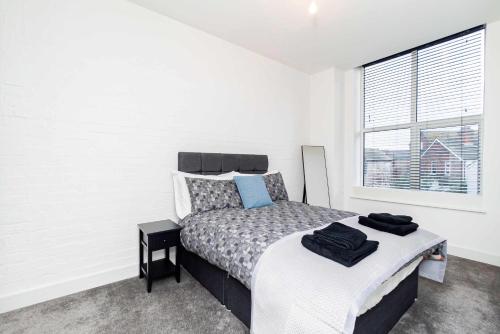 a bedroom with a bed and a window at Spacious 2 Bedroom Apartment in Central Tonbridge in Kent