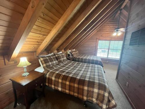 a bedroom with a bed in a wooden cabin at Bear Necessities located near East Port Marina & Dale Hollow in Alpine